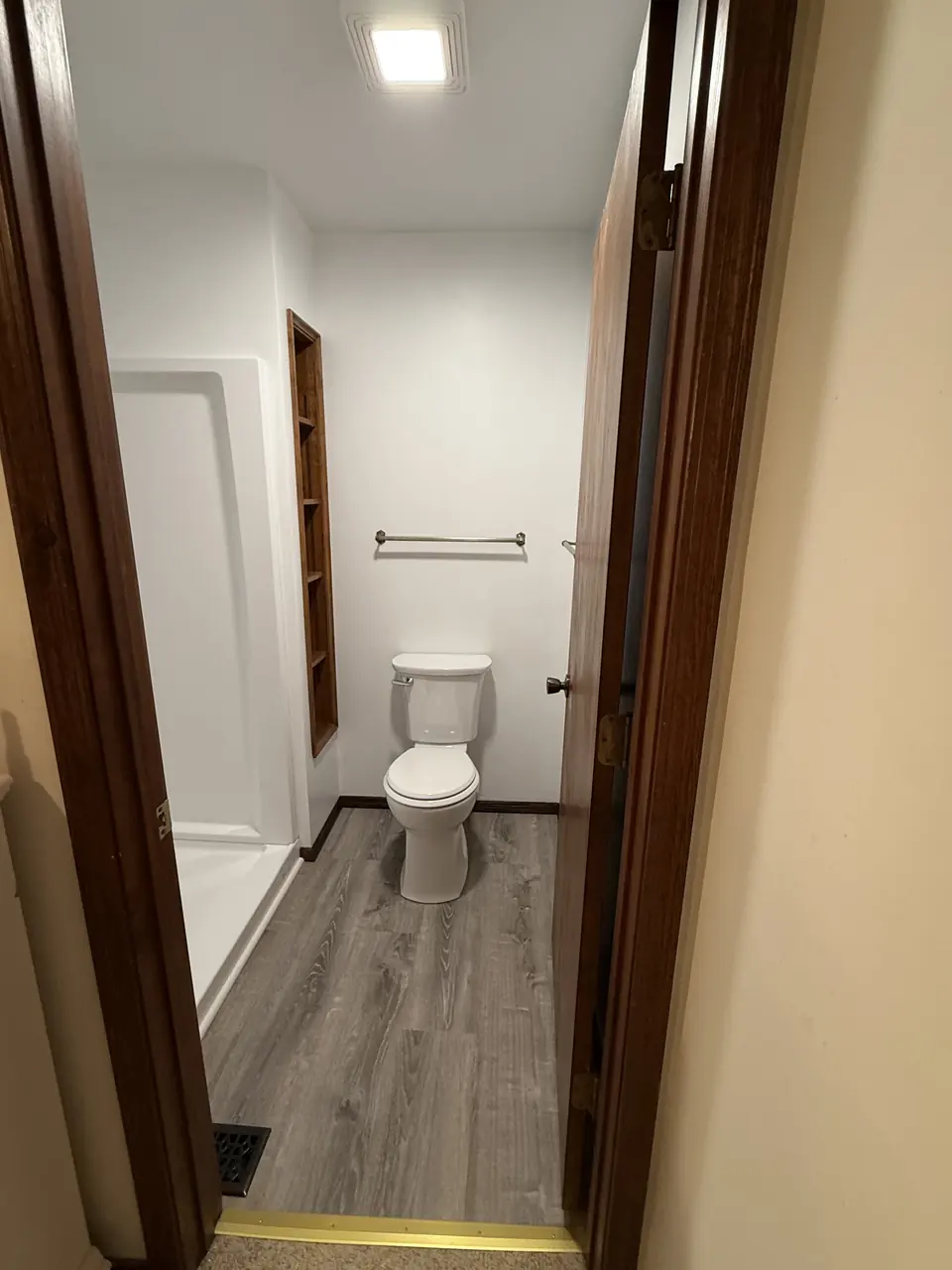 After: Dated bathroom remodeled with a new shower, flooring, and paint