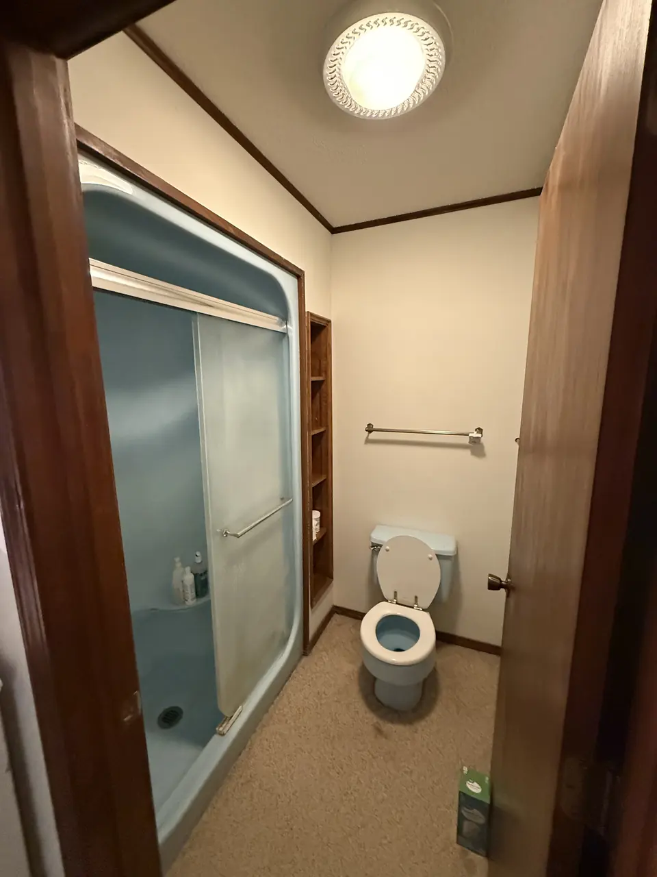 Before: Dated bathroom remodeled with a new shower, flooring, and paint