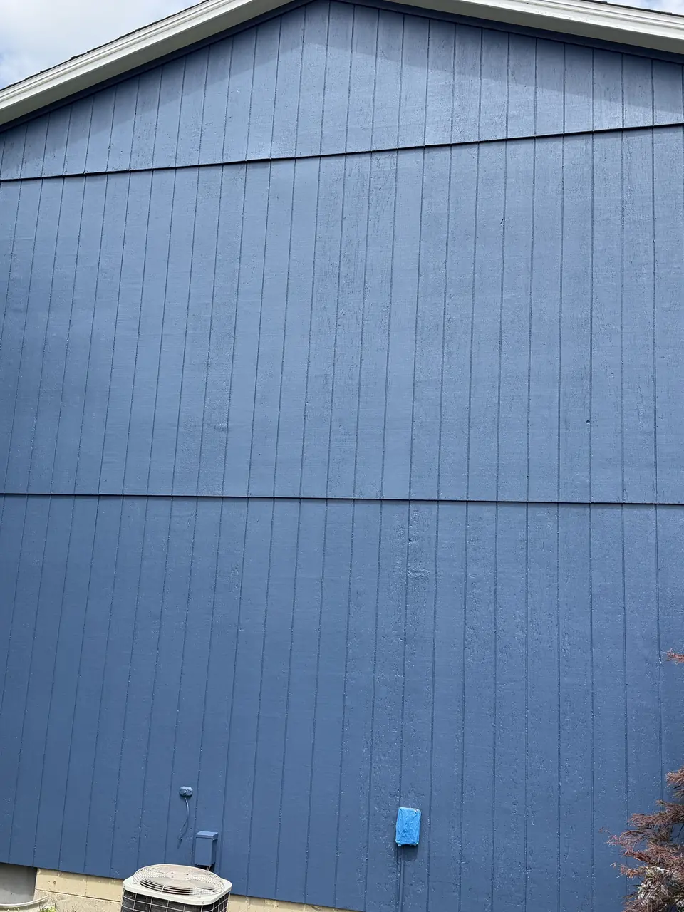 After: Weathered yellow siding repainted blue