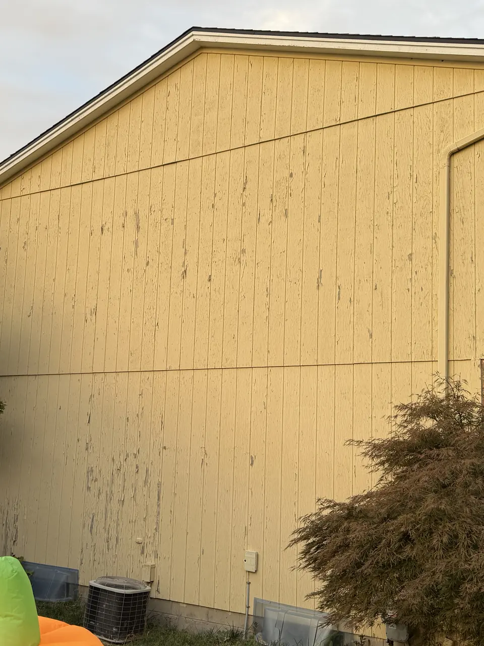 Before: Weathered yellow siding repainted blue