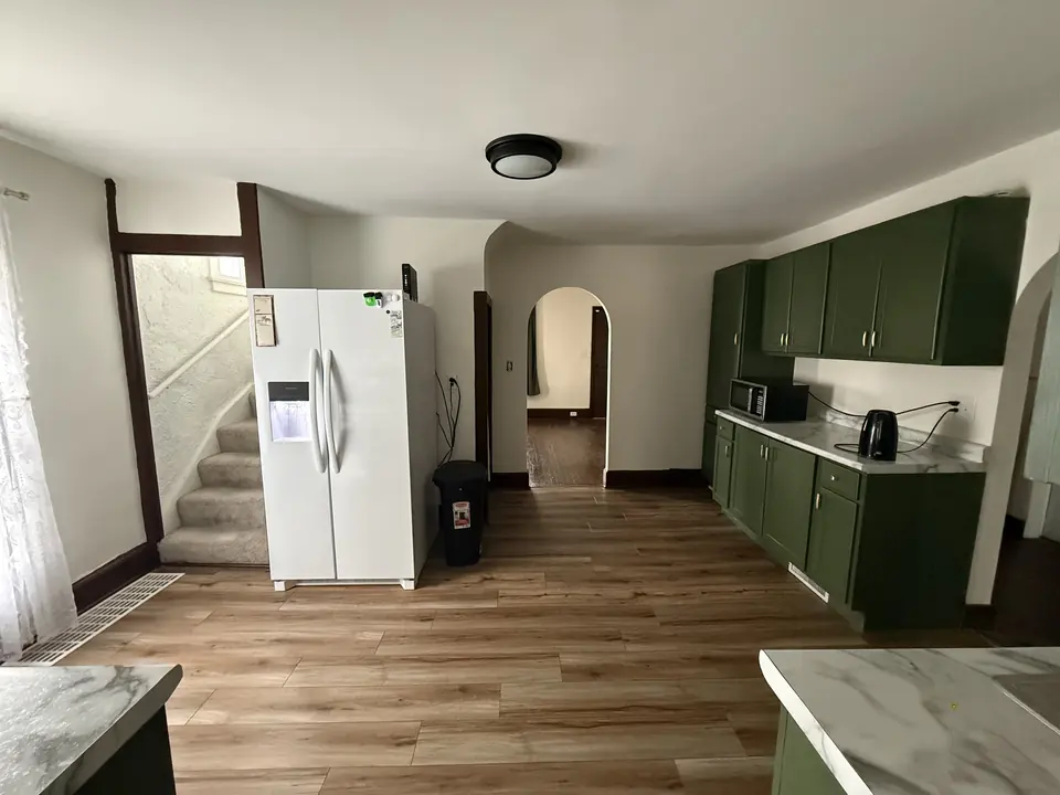 After: Kitchen walls repainted from yellow to bright white with refreshed floors