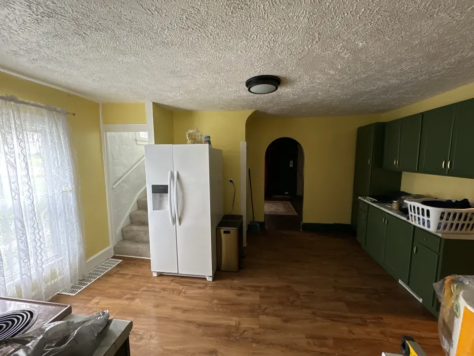 Before: Kitchen walls repainted from yellow to bright white with refreshed floors