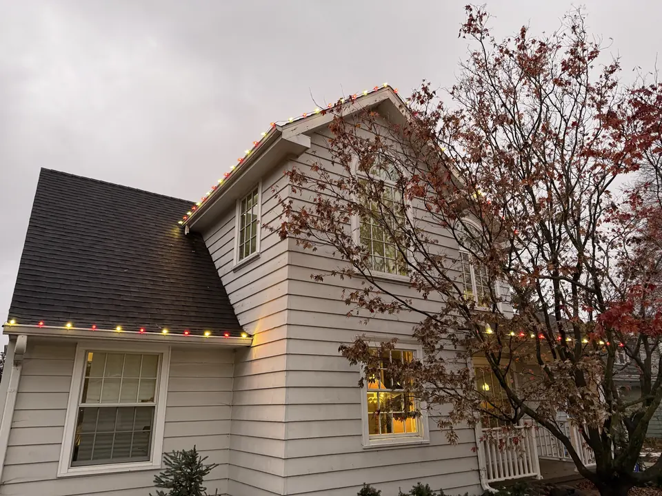 Two-story home with roofline lights at dusk
