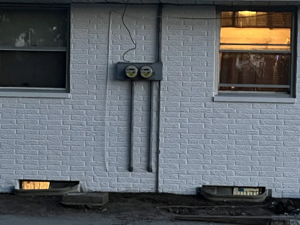 Brick wall mid-way through being painted white
