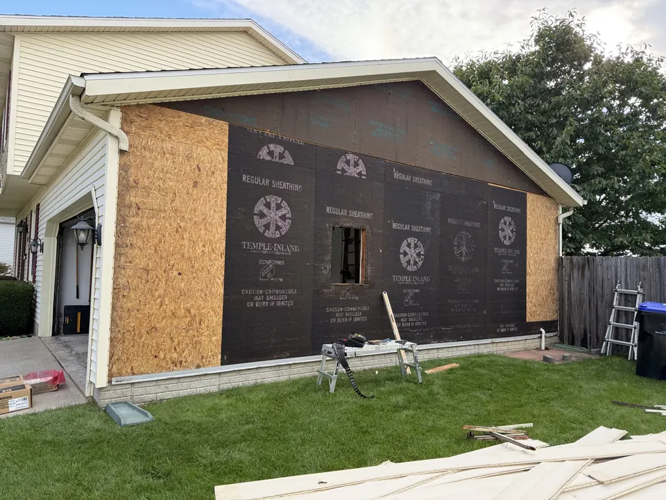 Garage wall stripped to new sheathing and house wrap with a new window opening