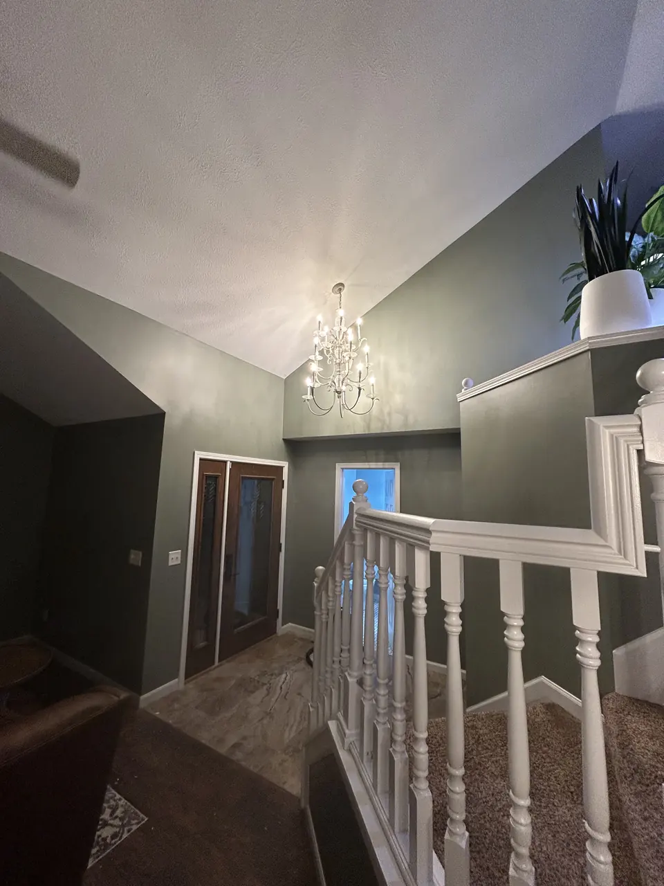 Entryway and staircase painted deep green with white trim