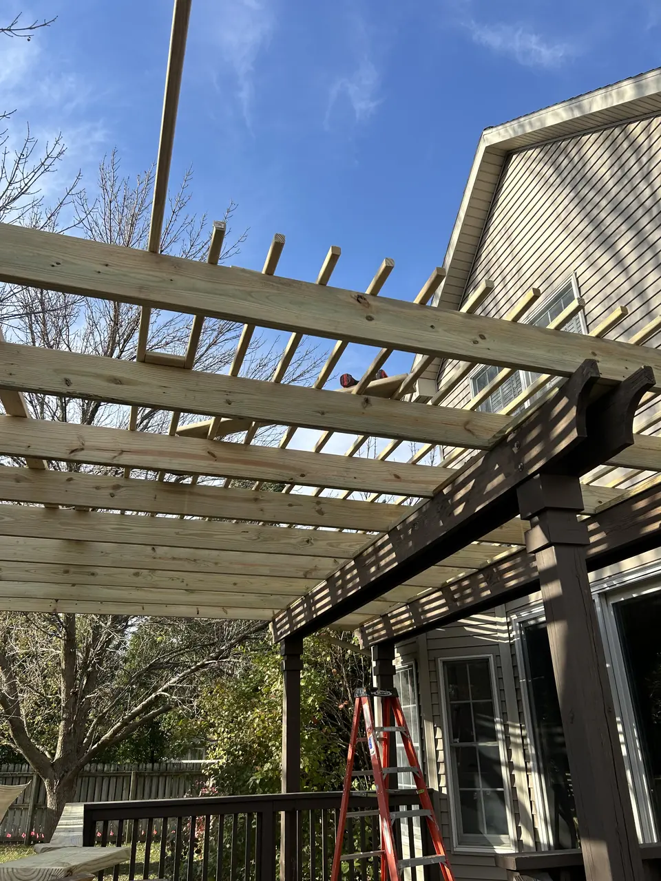 Pergola rebuilt with new lumber before staining