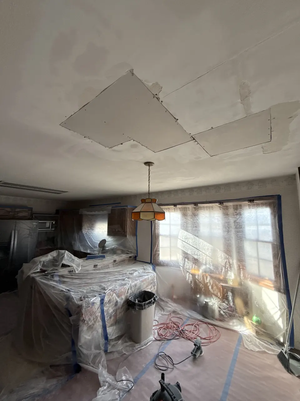 Kitchen fully sealed in plastic during popcorn ceiling removal
