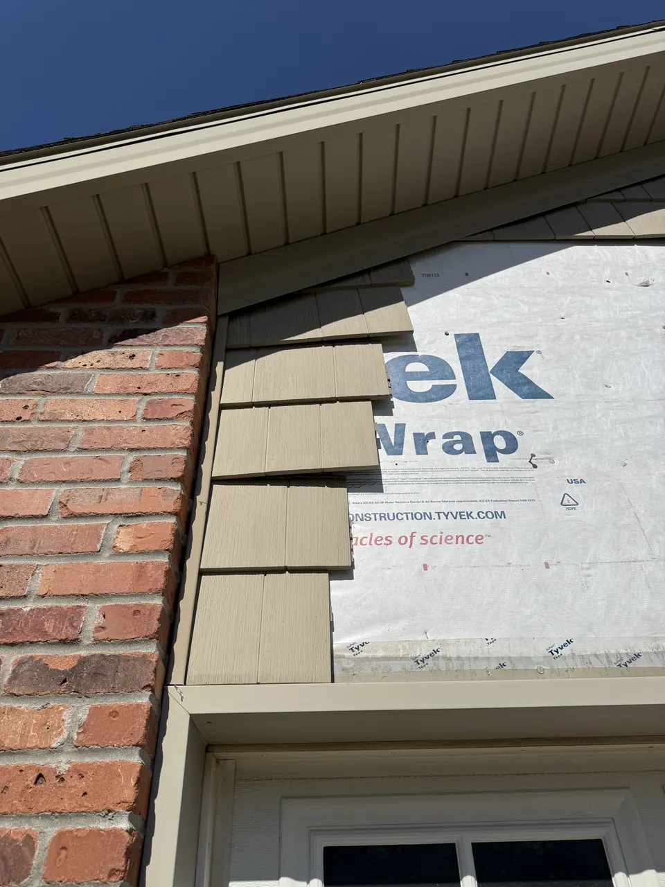 Shake-style vinyl siding being replaced on a garage gable